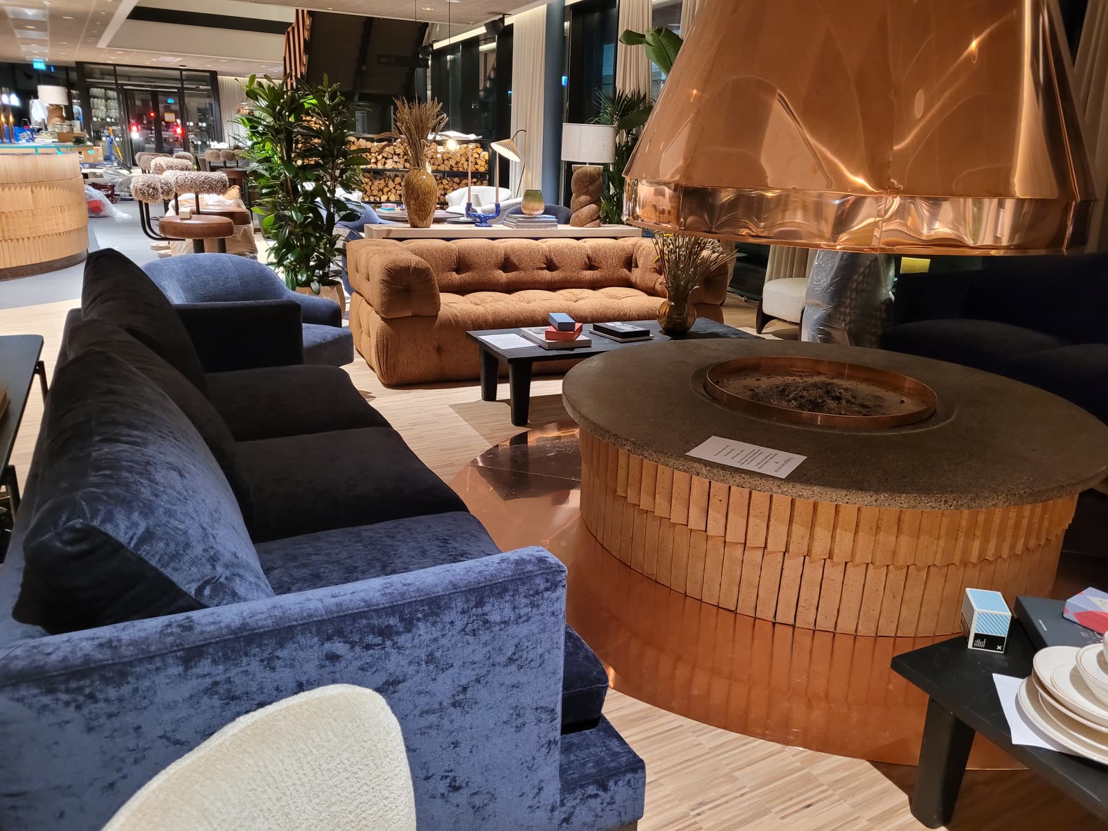 Hotel lobby with copper fireplace, blue velour chairs and velvet sofa