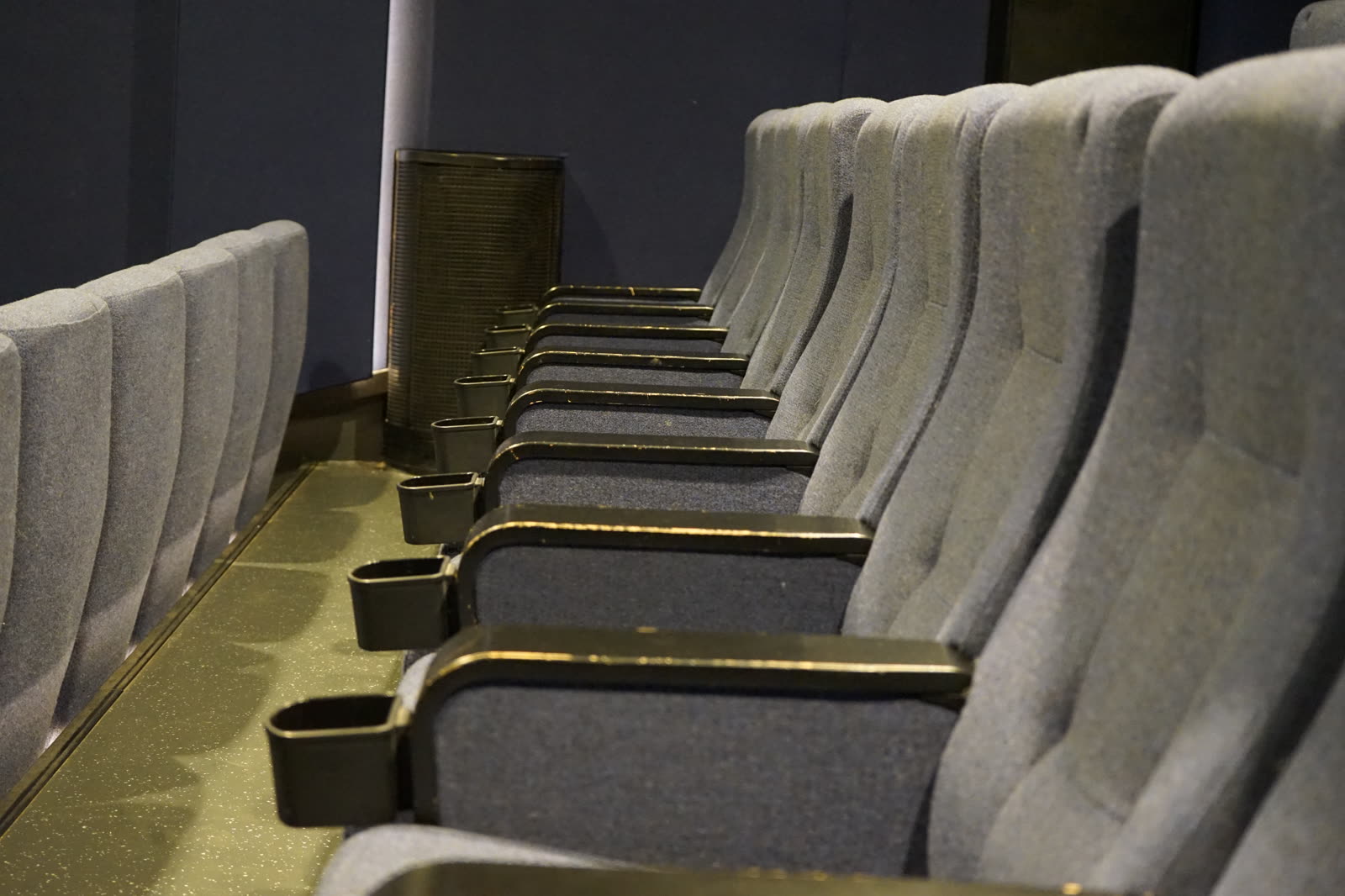 Close-up of grey cinema seats with cup holders